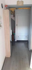 a room with a white cabinet and a wooden floor at Apartment Philippeville 18 m² Garden in Philippeville