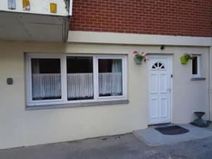 a white house with a white door and windows at Apartment Philippeville 18 m² Garden in Philippeville