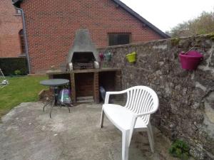 a white chair and a table and a brick wall at Apartment Philippeville 18 m² Garden in Philippeville +8 photos
