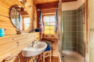a bathroom with a sink and a mirror and a tub at Der Fuchsbau - 3 separate Blockhäuser - ruhige Lage - 50m bis zum Wald - eingezäunter Garten in Bad Sachsa