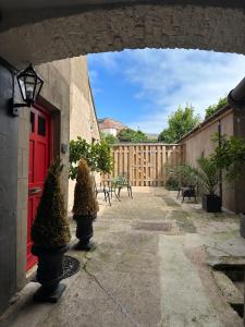 a courtyard with a red door and a fence at Strother's Townhouse in Berwick-Upon-Tweed
