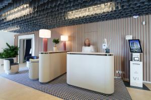 a man standing behind a counter in a lobby at Vi Place in Lido di Camaiore