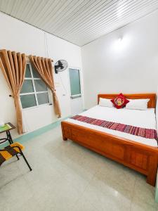 a bedroom with a bed and a table and a window at Linh Chi Hotel in Mù Cang Chải