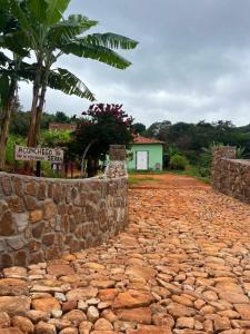 a stone path with a stone wall and a palm tree at Aconchego Da Serra in Triunfo