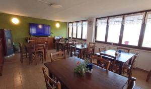 a restaurant with tables and chairs and a television at Desdemona House Pub in Castellino Tanaro