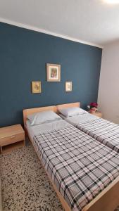 a bedroom with two beds and a blue wall at Desdemona House Pub in Castellino Tanaro