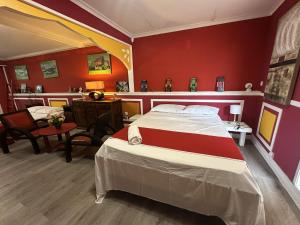 a bedroom with a bed and a red wall at Le coin des romarins in Saint-André