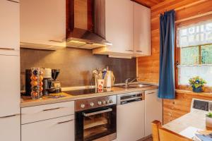 a kitchen with white cabinets and a stove top oven at Der Fuchsbau - 3 separate Blockhäuser - ruhige Lage - 50m bis zum Wald - eingezäunter Garten in Bad Sachsa
