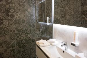 a bathroom with a sink and a mirror at Hotel De Nac in Nago-Torbole +35 photos