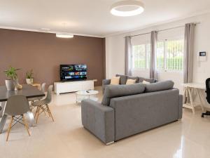 a living room with a gray couch and a table at Villa La Perla - Pool, Garden & Barbecue - AC in Mutxamel