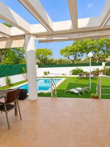 an outdoor patio with a view of a yard and a pool at Villa La Perla - Pool, Garden & Barbecue - AC in Mutxamel