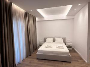 a white room with a bed and a window at Riviera Central Escape in Sarandë