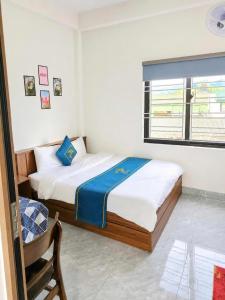 a bedroom with a bed and a window at Lộc Phát Hotel Mộc Châu in Làng Môn