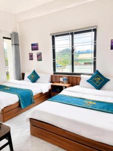 a bedroom with two beds and a window at Lộc Phát Hotel Mộc Châu in Làng Môn