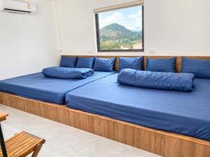 a large bed with blue pillows in a room at Lộc Phát Hotel Mộc Châu in Làng Môn