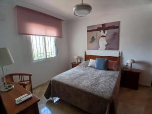 a bedroom with a bed and a desk and a bed sidx sidx sidx at Casa Lunamar in Rincón de la Victoria