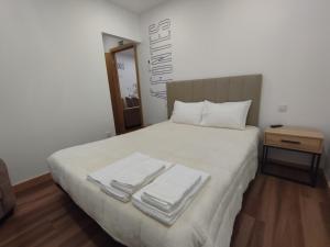 a bedroom with a bed with towels on it at SeiaVilla - 4 Fontes in Seia