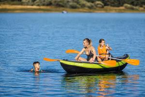 a woman and two children in a boat in the water at Kampaoh Picos de Urbión in Abejar