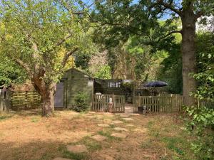 a backyard with a wooden fence and an umbrella at Hedgehog Lodge in Colwall