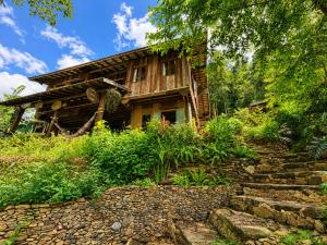 a log house with a stone path in front of it at Indigo Homestay in Ban Huai Pong +29 photos