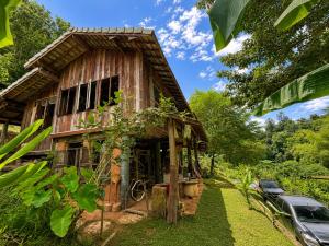 an old wooden house with a car parked next to it at Indigo Homestay in Ban Huai Pong