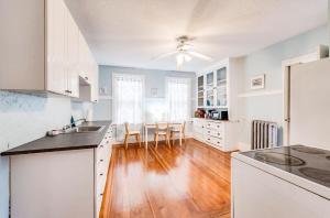 a kitchen with white cabinets and a hard wood floor at YLD Rooms - Shared Bathrooms & Spaces in Springfield