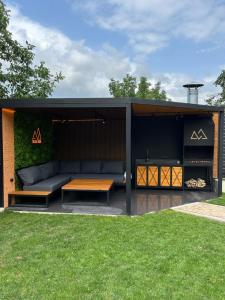 a black shed with a couch and a table at Dilijan House in Dilijan