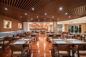 a dining room with wooden tables and chairs at Park Inn by Radisson Al Khobar in Al Khobar