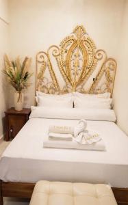 a bed with a gold headboard with a towel on it at Halil Bey Luxury Apartments in Kavála +37 photos