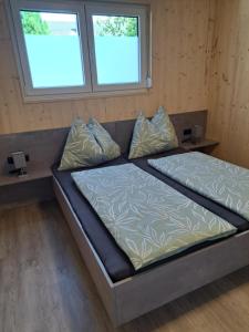a large bed in a room with two windows at Ferienhaus Brunner in Höchst