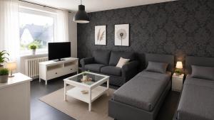 a living room with a couch and a tv at Pulheim Living 3 in Pulheim