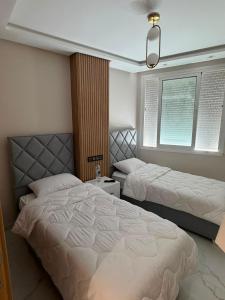 a bedroom with two beds and a window at appartement de luxe tanger in Tangier