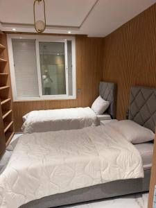 a bedroom with two beds and a window at appartement de luxe tanger in Tangier