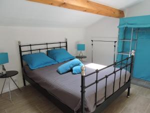 a bedroom with a bed with blue pillows at Les Provences Bleu et Verte in Solliès-Pont