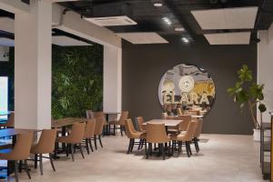 a dining room with tables and chairs and plants at Planet Hotels ONE - Adults Only 16 years in El Arenal