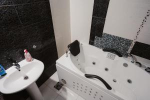 a bathroom with a white tub and a sink at The Red Lounge in Strumica