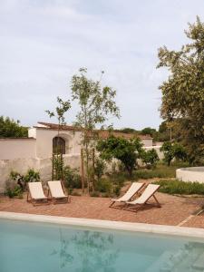 two lounge chairs sitting next to a swimming pool at Casa Dez - Pedrogão do Alentejo in Pedrógão