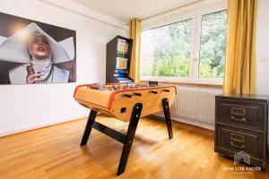 a room with a foosball table in front of a window at La VILLA du Reims - Mon Gîte Facile in Colmar