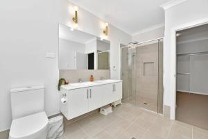 a bathroom with a toilet sink and a shower at Hunter Valley Bercuti in North Rothbury
