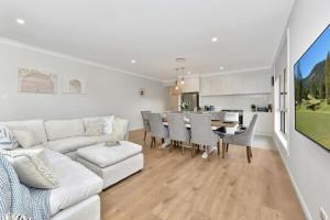 a living room with a white couch and a table at Hunter Valley Bercuti in North Rothbury +9 photos