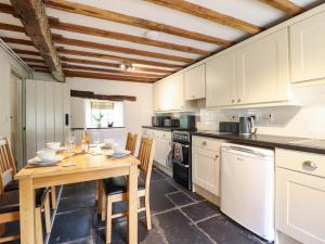 a kitchen with a wooden table and a table and chairs at Frondirion in Machynlleth