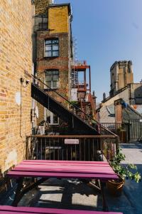 a pink bench sitting in front of a brick building at Hostelle - women only hostel London in London