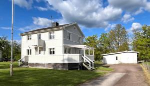 a white house with a porch and a garage at Villa Oakfield in Fröseke