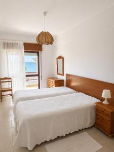 a bedroom with two beds and a large window at Apartamentos Carteia in Quarteira