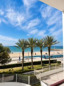 a row of palm trees on the beach at Apartamentos Carteia in Quarteira