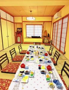 a large dining room with a long table with dishes at 島の宿 in Toba