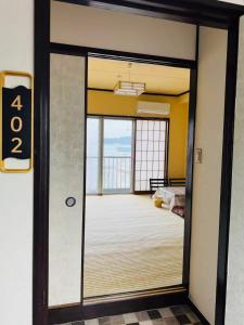 a door leading to a room with a balcony at 島の宿 in Toba