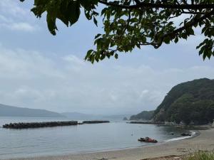 a boat in the water on a beach at 島の宿 in Toba +4 photos