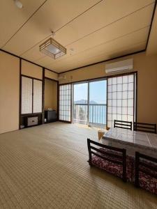 a large room with a large room with a large window at 島の宿 in Toba