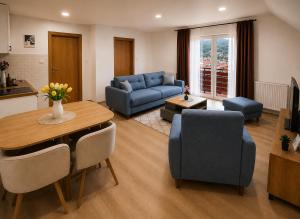 a living room with a table and a blue couch at Apartmani Resimic in Ivanjica